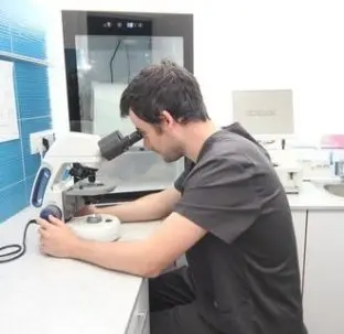 Sergio Herrero, veterinario, observando una muestra al microscopio